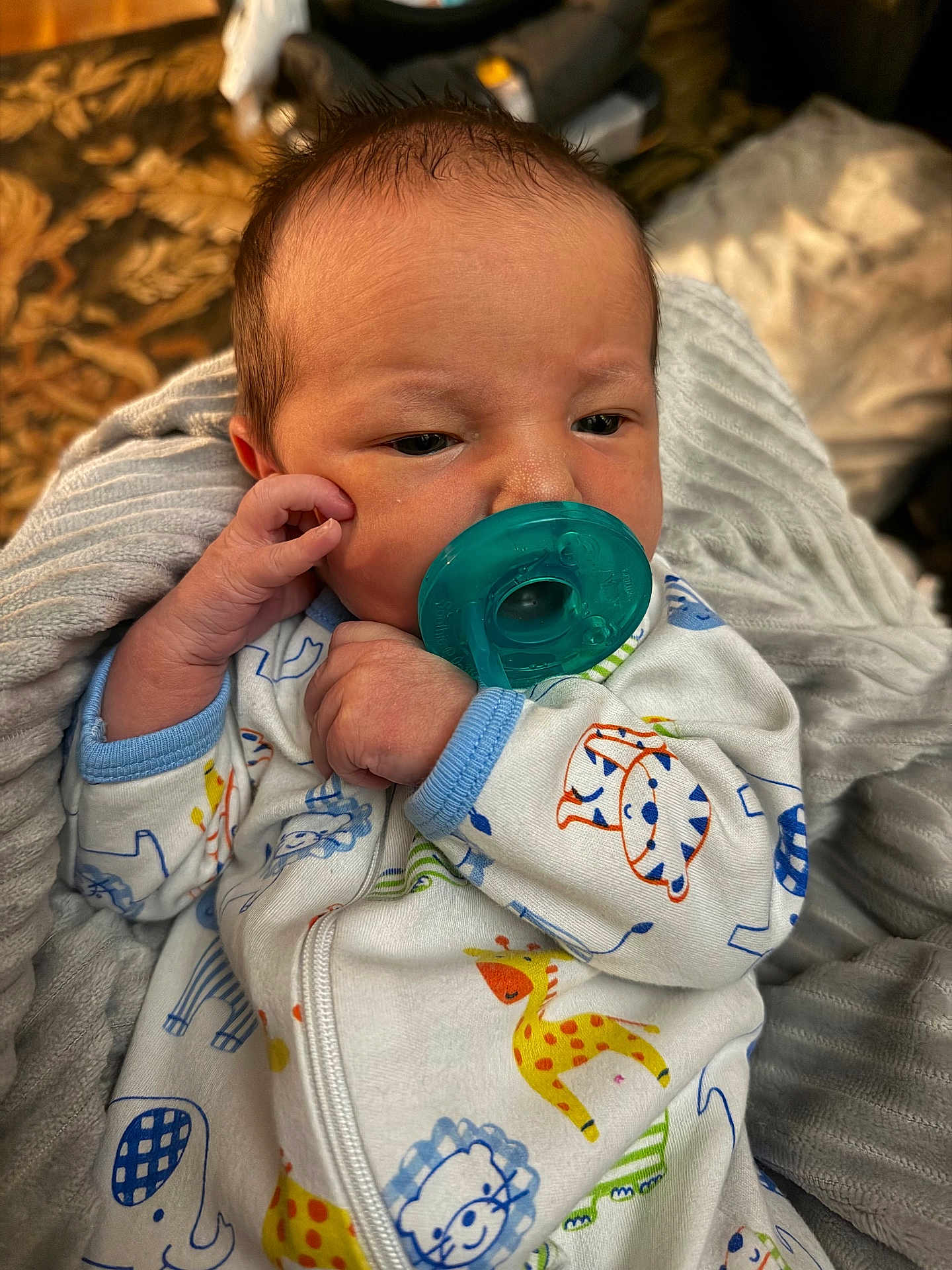 Beau is registered to the contest to win money with this photo: baby, infant, pacifier, onesie, animal_print, blanket, sleepwear, child, newborn, cute, soft, cozy, hand, face, portrait, indoors, resting, young, person, clothing