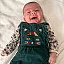 Charlie participe au concours pour gagner de l'argent avec cette photo : baby, blanket, child, clothing, cute, embroidered, face, floral, green_outfit, hands, happy, head, indoor, infant, lying_down, portrait, smiling, soft_texture, toddler, young_child