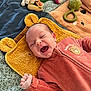 baby, smiling, infant, toy, blanket, towel, cute, happy, clothing, lying_down, face, hand, playful, indoor, soft_toys, colorful, child, expression, comfort, cuddle
