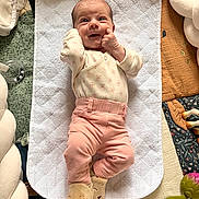 Charlie participe au concours pour gagner de l'argent avec cette photo : baby, infant, smile, lying, quilted_pad, pink_pants, slippers, soft_toys, blanket, cozy, cute, happy, face, hand, footwear, child, indoors, play_area, cotton_clothing, infant_care
