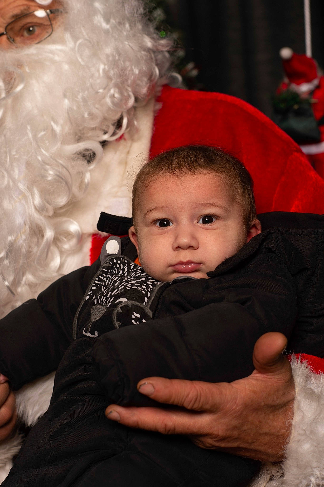 Tommy a rejoint le concours — aidez-le/la à gagner de superbes lots ! baby, baby_toddler_clothing, beard, child, christmas, costume_hat, event, facial_expression, fictional_character, fun, gesture, happy, hat, head, human_body, interaction, lap, person, santa_claus, toddler