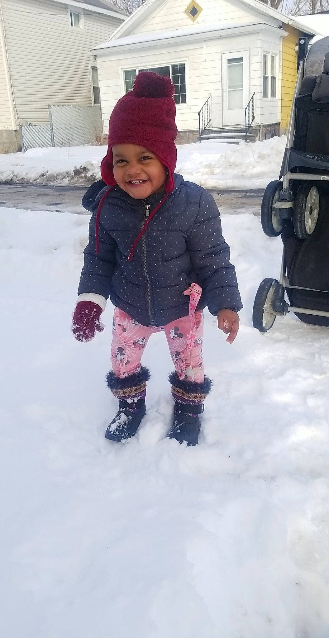 Jazlynn is registered to the contest to win money with this photo: automotive_tire, beanie, child, face, freezing, fun, headwear, human_body, jacket, jeans, joy, knit_cap, person, playing_in_the_snow, precipitation, recreation, smile, snow, tire, toddler