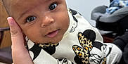 Aurora joined the competition — help win amazing prizes! baby, infant, child, person, hand, clothing, mickey_mouse, minnie_mouse, pattern, leopard_print, face, eyes, expression, indoor, furniture, car_seat, cute, closeup, portrait, holding