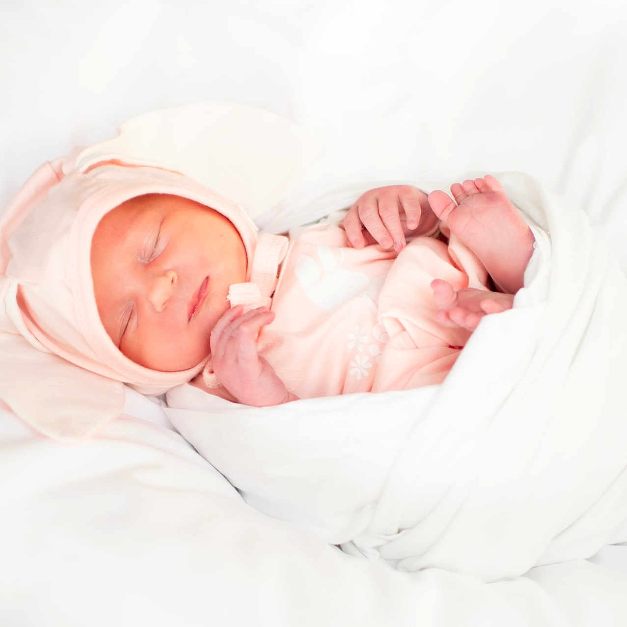 Daisy is registered to the contest to win money with this photo: baby, blanket, bunny_ears, child, cozy, cute, hands, hat, indoors, infant, newborn, peaceful, pink_clothing, portrait, resting, sleeping, soft, swaddled, tiny_feet, white_background