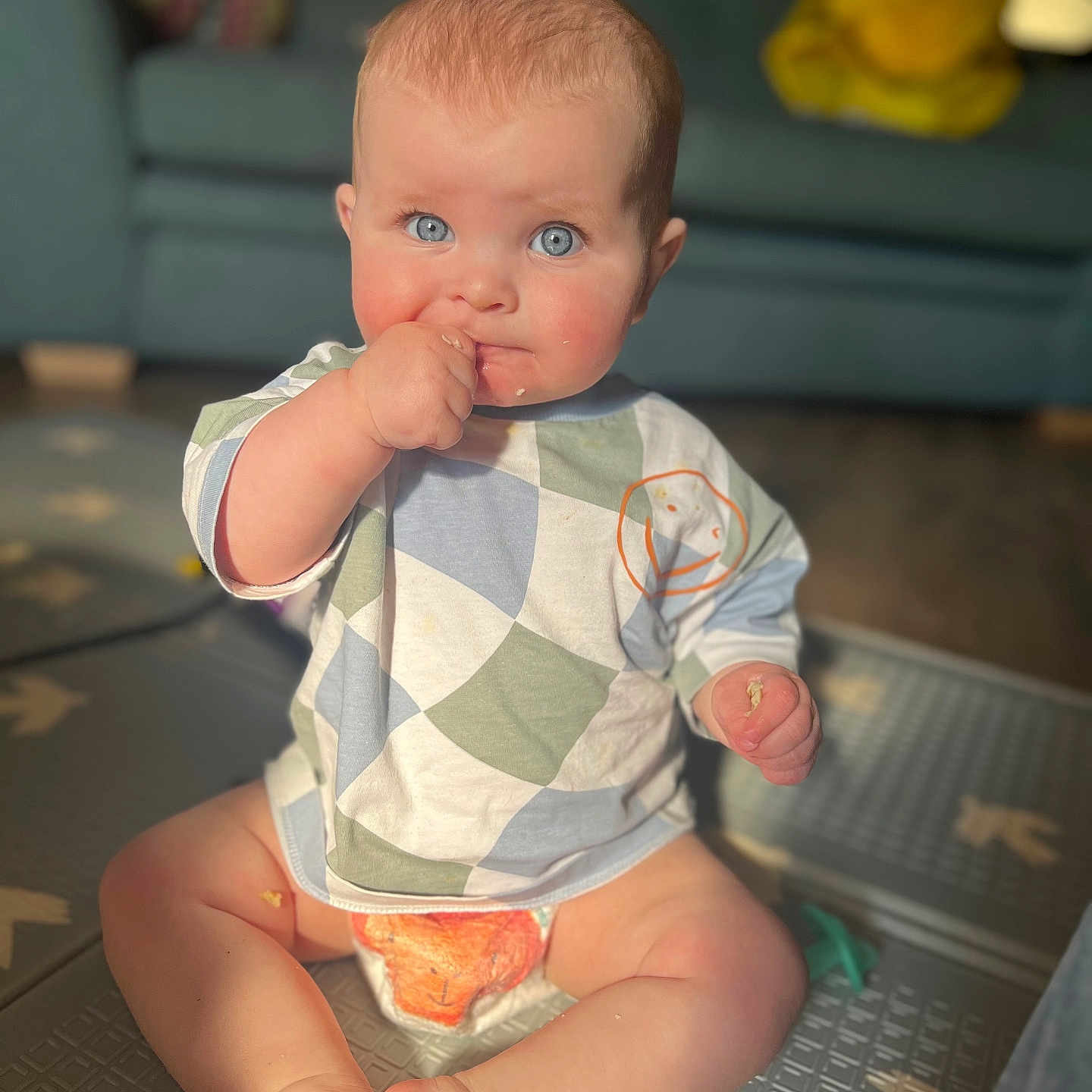 Noah is registered to the contest to win money with this photo: architecture, baby, bodypart, building, clothing, couch, face, finger, furniture, hand, head, indoors, livingroom, pants, person, photography, portrait, room, sitting, t_shirt