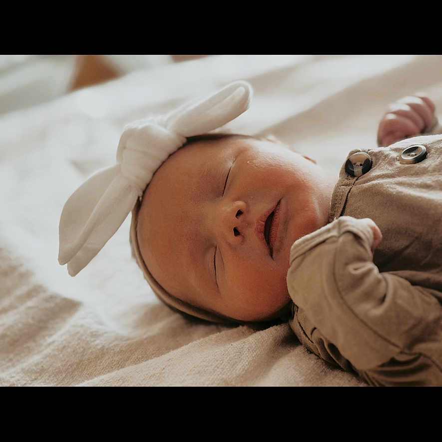 Huntleigh is registered to the contest to win money with this photo: baby, bodypart, bonnet, cap, clothing, face, finger, glove, hand, happy, hat, head, hood, hoodie, newborn, person, photography, portrait, sleeping, smile