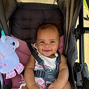 Naari joined the competition — help win amazing prizes! baby, baby_accessory, baby_toy, black_straps, child, clothing, cute, footwear, happy, infant, outdoor, person, pink_cushion, plush_unicorn, portrait, seatbelt, smiling, stroller, sunlight, toy