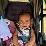 baby, baby_accessory, baby_toy, black_straps, child, clothing, cute, footwear, happy, infant, outdoor, person, pink_cushion, plush_unicorn, portrait, seatbelt, smiling, stroller, sunlight, toy
