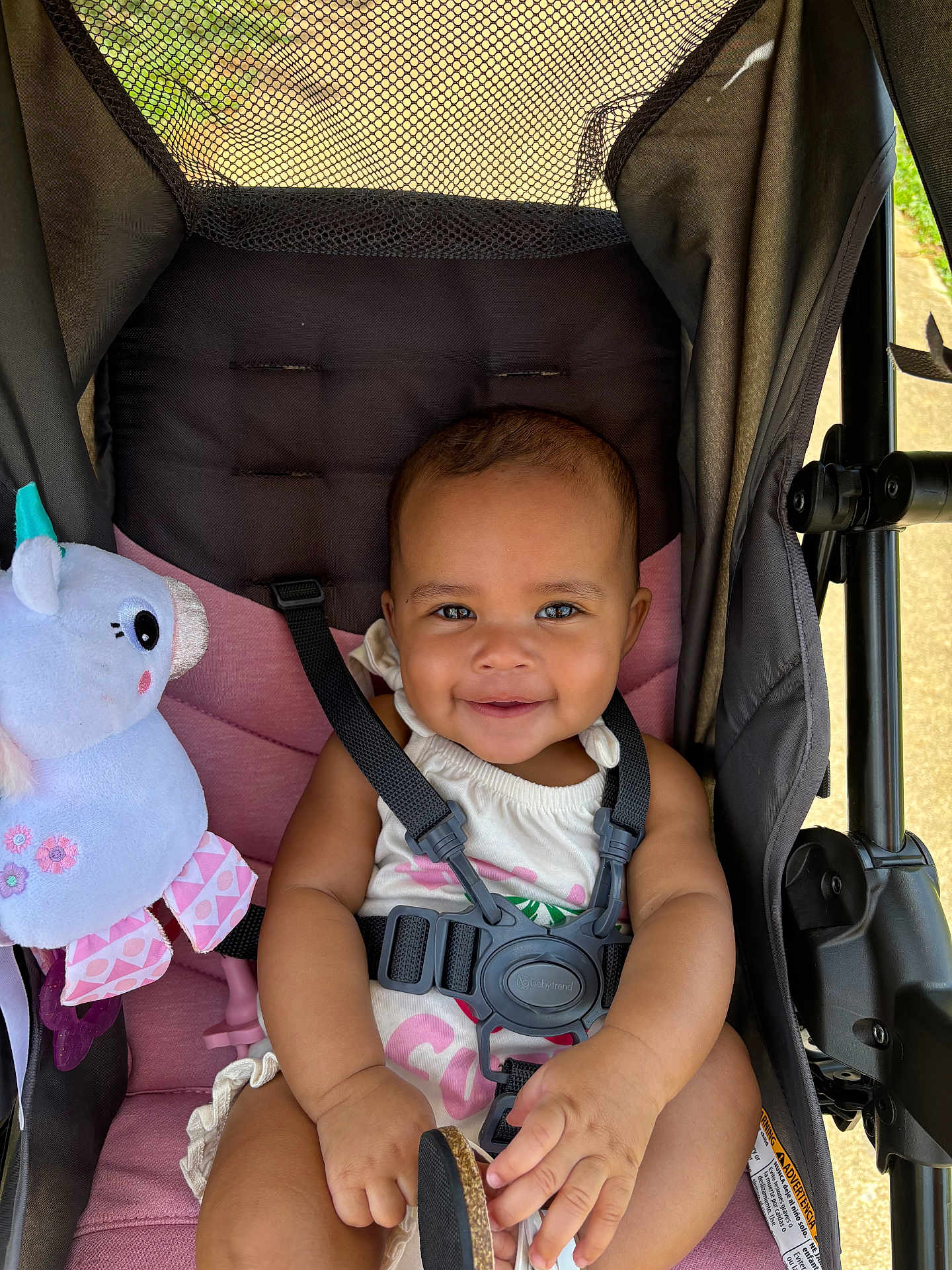 Naari joined the competition — help win amazing prizes! baby, baby_accessory, baby_toy, black_straps, child, clothing, cute, footwear, happy, infant, outdoor, person, pink_cushion, plush_unicorn, portrait, seatbelt, smiling, stroller, sunlight, toy
