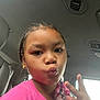 child, girl, selfie, pink_shirt, braids, beads, car_interior, peace_sign, playful, portrait, face, earrings, casual, indoor, young, cute, expression, hand_gesture, window, seat