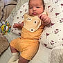 Joseph Vinícius participe au concours pour gagner de l'argent avec cette photo : baby, infant, child, pillow, blanket, toy, orange_clothing, bib, socks, bed, soft_fabric, face, person, indoor, cute, relaxed, patterned, lying_down, comfort, home