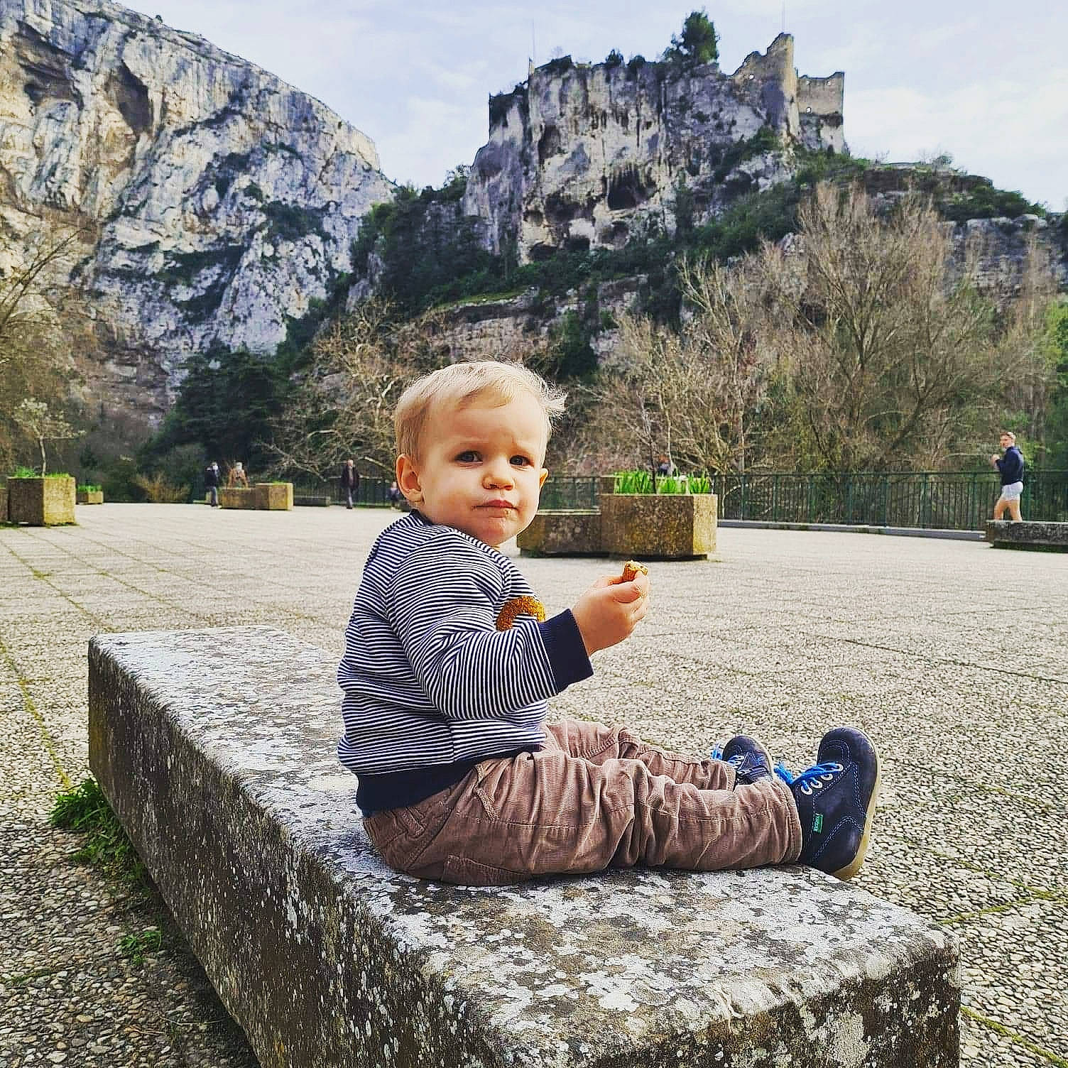 Aydan participe au concours pour gagner de l'argent avec cette photo : grass, grass_family, happy, landscape, leisure, mountain, nature, people_in_nature, person, plant, road_surface, rock, sitting, sky, standing, summer, toddler, travel, tree, wall