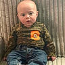 baby, blanket, boots, camouflage, child, clothing, curious, cute, expression, face, indoor, infant, jeans, orange_patch, person, portrait, sitting, soft, texture, young