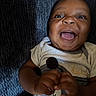 Dedrick is registered to the contest to win money with this photo: baby, infant, child, smiling, happy, portrait, close_up, face, open_mouth, eyes, hands, plush_toy, shirt, clothing, couch, indoor, home, sitting, dark_background, photography