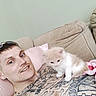 animal, beige, cat, chain_necklace, companion, couch, cute, furniture, home, indoor, kitten, man, pet, pink_pillow, relaxing, short_hair, smile, tattoo, tattoos, young_adult