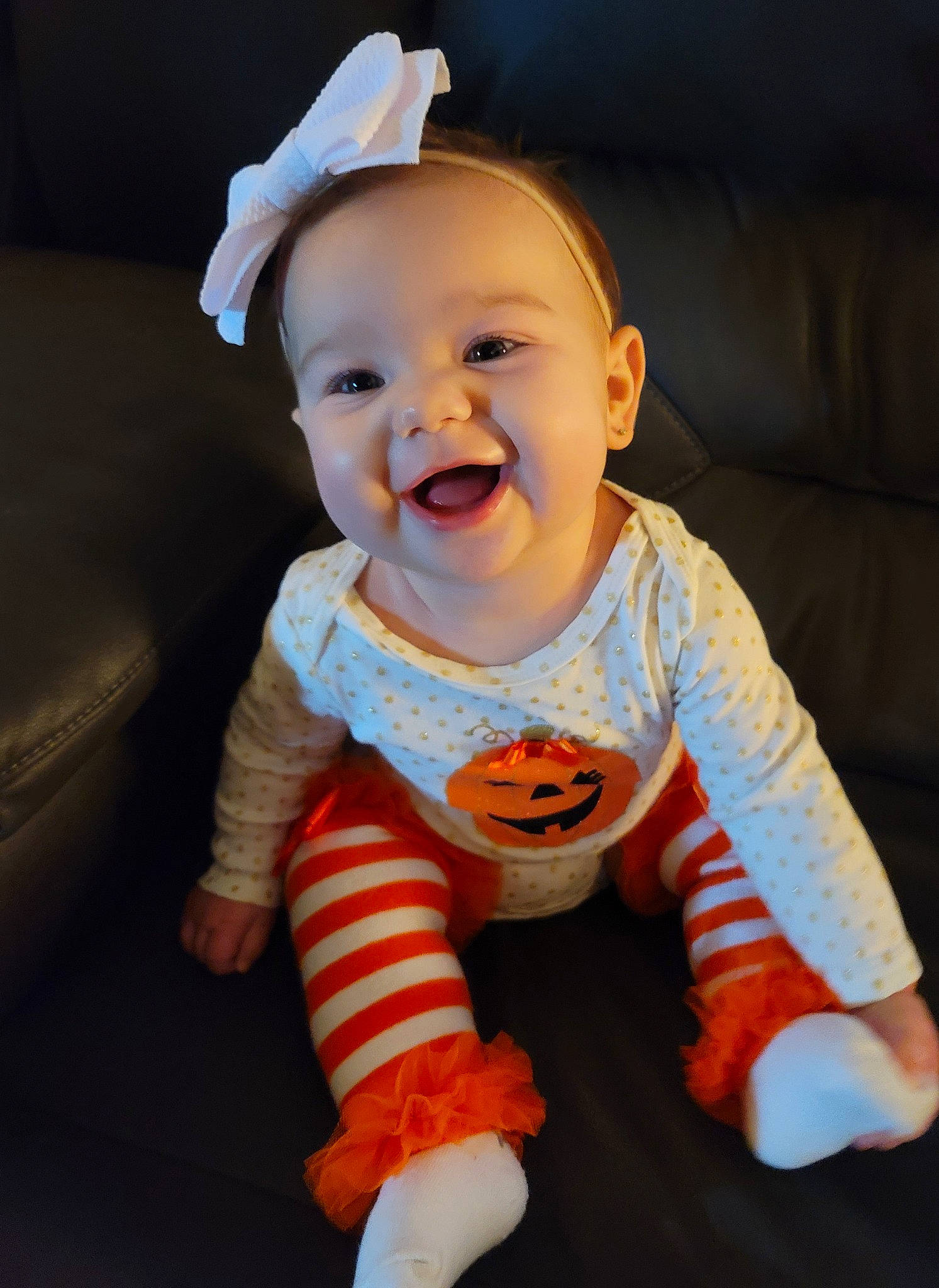 Vera is registered to the contest to win money with this photo: baby, baby_laughing, cheek, child, ear, eye, face, facial_expression, fun, happy, head, mouth, orange, person, sitting, skin, sleeve, smile, toddler, yellow
