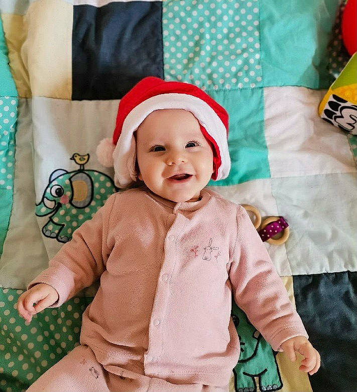 Isia participe au concours pour gagner de l'argent avec cette photo : baby, baby_toddler_clothing, cap, child, comfort, event, eye, face, green, happy, head, headwear, holiday, linens, outerwear, pattern, person, product, sleeve, smile