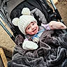 baby, smiling, stroller, blanket, hat, mittens, outdoor, child, cold_weather, cozy, happy, infant, cute, warm_clothing, person, portrait, baby_accessories, playful, winter, seat