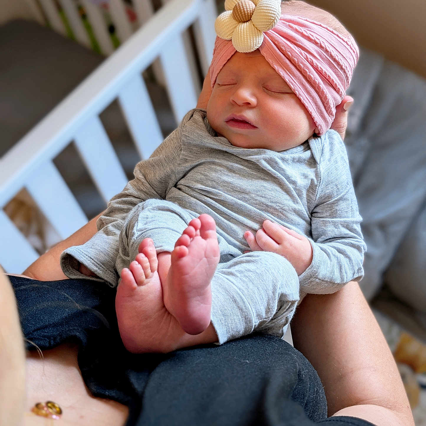 Liv is registered to the contest to win money with this photo: baby, beanie, bed, blanket, bodypart, bonnet, cap, clothing, crib, face, finger, furniture, hand, hat, head, infantbed, jeans, newborn, pants, person