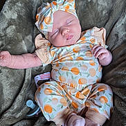Myla is registered to the contest to win money with this photo: baby, sleeping, infant, blanket, headband, clothing, pacifier, soft_texture, cute, cozy, resting, pink_socks, patterned_outfit, newborn, child, portrait, indoor, comfort, peaceful, toddler