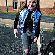 Amiah joined the competition — help win amazing prizes! asphalt, blue_vest, brick_wall, building, casual_clothing, child, girl, happy, jeans, long_hair, outdoor, parking_lot, person, ripped_jeans, sidewalk, smile, sunlight, vest, walking, young