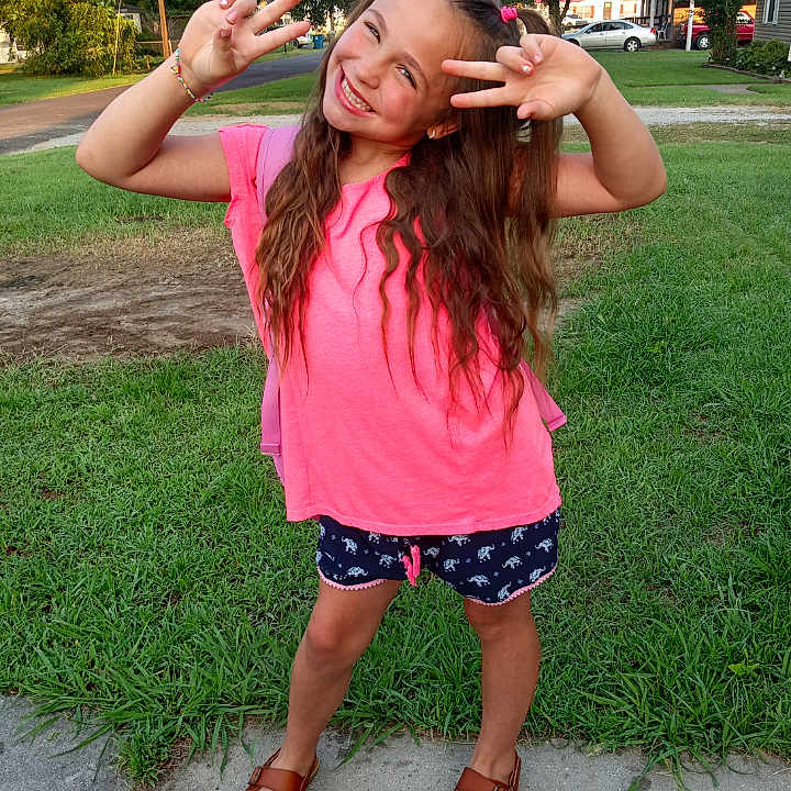 Amiah is registered to the contest to win money with this photo: bodypart, child, clothing, face, female, finger, footwear, grass, hand, head, nature, outdoors, park, person, photography, plant, portrait, sandal, shorts, summer