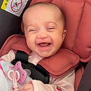 Jream is registered to the contest to win money with this photo: baby, infant, smiling, laughing, car_seat, pacifier, pink, blanket, clothing, child, cute, happy, face, head, seatbelt, comfort, indoor, toddler, bundle, joy