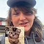 animal, cap, casual, cat, cute, digital_insertion, fluffy, fur, hair, hoodie, kitten, outdoor, person, portrait, selfie, sky, small, smile, wide_eyes, young