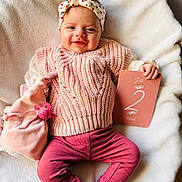 Mélyanah a rejoint le concours — aidez-le/la à gagner de superbes lots ! baby, infant, smiling, headband, pink_clothing, knitwear, plush_toy, pacifier, milestone_card, blanket, soft_texture, indoor, cute, happy, portrait, child, two_months, cozy, relaxed, lying_down