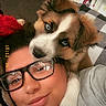 Bear is registered to the contest to win money with this photo: person, dog, puppy, glasses, couch, indoor, affection, face, closeup, cozy, pet, lying_down, cute, snuggle, warm, comfortable, casual, home, young_adult, portrait