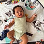 baby, smiling, play_mat, animal_patterns, infant, happy, child, carpet, toes, nail_polish, cute, indoors, clothing, sleeveless_onesie, chubby_arms, chubby_legs, toy, colorful, lying_down, soft
