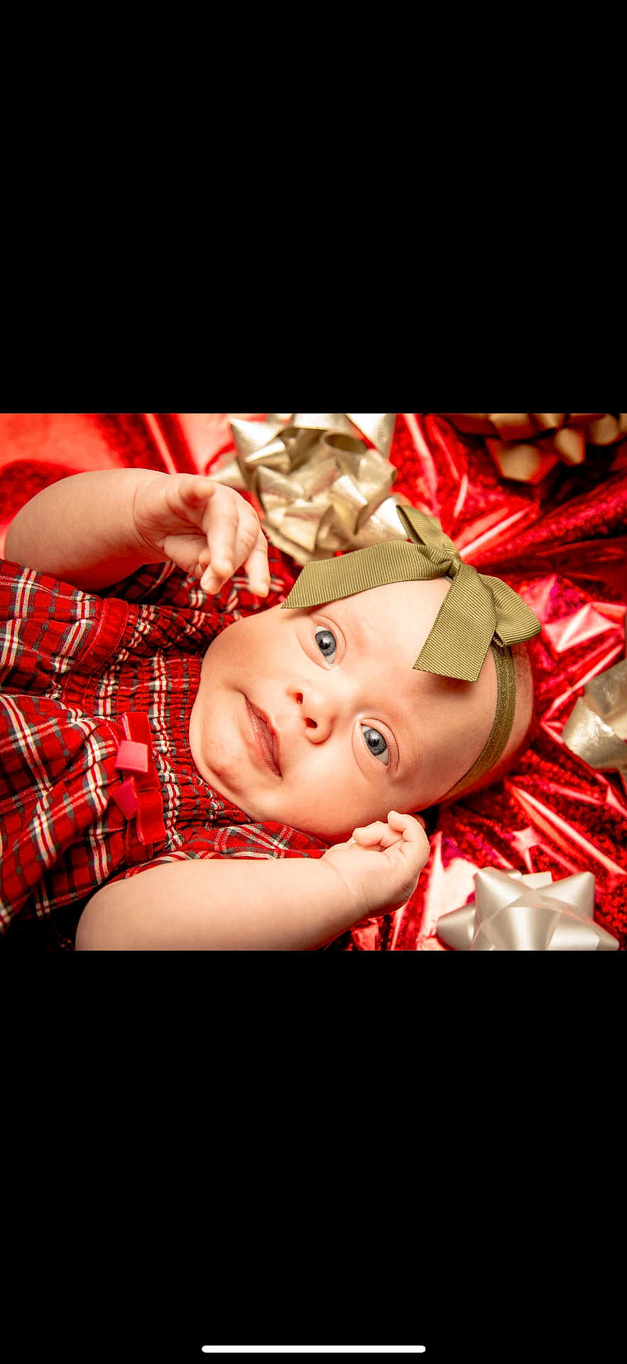 Sage is registered to the contest to win money with this photo: baby, infant, child, red_clothing, plaid, headband, bow, gift_wrapping, silver_bow, holiday, festive, portrait, cute, smiling, face, hands, blue_eyes, lying_down, celebration, closeup