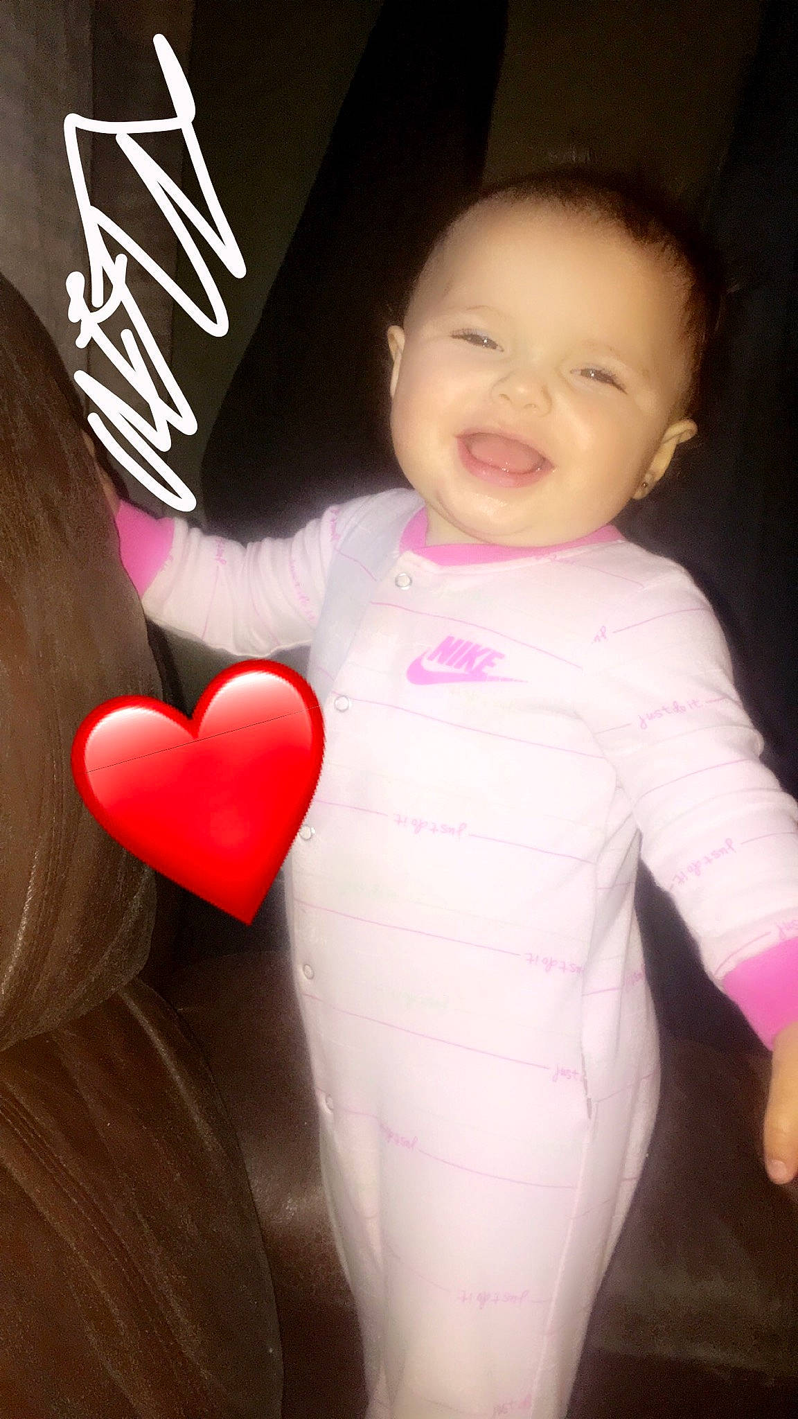 Izabella is registered to the contest to win money with this photo: arm, baby_toddler_clothing, cheek, cool, face, finger, gesture, hair, happy, head, human_body, joy, lip, neck, outerwear, person, pink, sleeve, smile, t_shirt