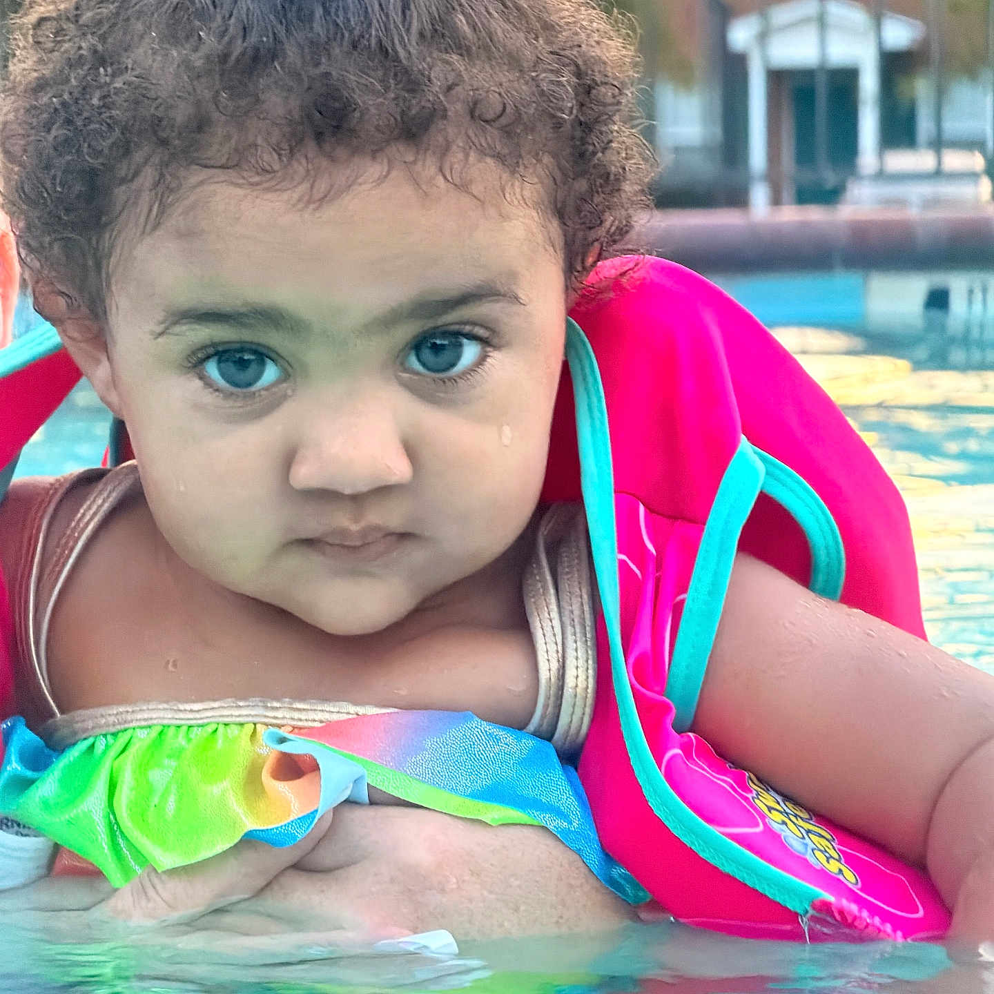 Bryilee joined the competition — help win amazing prizes! baby, blue_eyes, child, close_up, colorful_clothing, curly_hair, cute, floatation_device, outdoor, playtime, portrait, serious_expression, skin, summer, swimming_pool, swimwear, toddler, water, water_surface, young_child