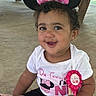 baby, birthday, birthday_ribbon, child, curly_hair, earrings, face, girl, happy, indoor, minnie_mouse, mouse_ears, outdoor_shelter, picnic_area, pink, portrait, seated, smiling, toddler, white_shirt