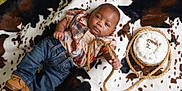 Ezekiel joined the competition — help win amazing prizes! baby, birthday_cake, brown_shoes, cake, celebration, child, cowboy_theme, cowhide_blanket, cute, decorated_cake, footwear, indoor, infant, jeans, lying_down, portrait, rope, shirt, smiling, two_months