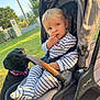Lino a rejoint le concours — aidez-le/la à gagner de superbes lots ! baby, child, toddler, stroller, dog, black_dog, outdoor, garden, grass, sunlight, snack, striped_clothing, blue_eyes, pet, leisure, seat, person, animal, daylight, curious