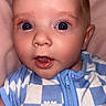 Dawson is registered to the contest to win money with this photo: baby, infant, blue_eyes, checkered_clothing, onesie, soft_background, pink, cute, portrait, closeup, child, expression, face, human, young, lying_down, small_person, adorable, curious, skin