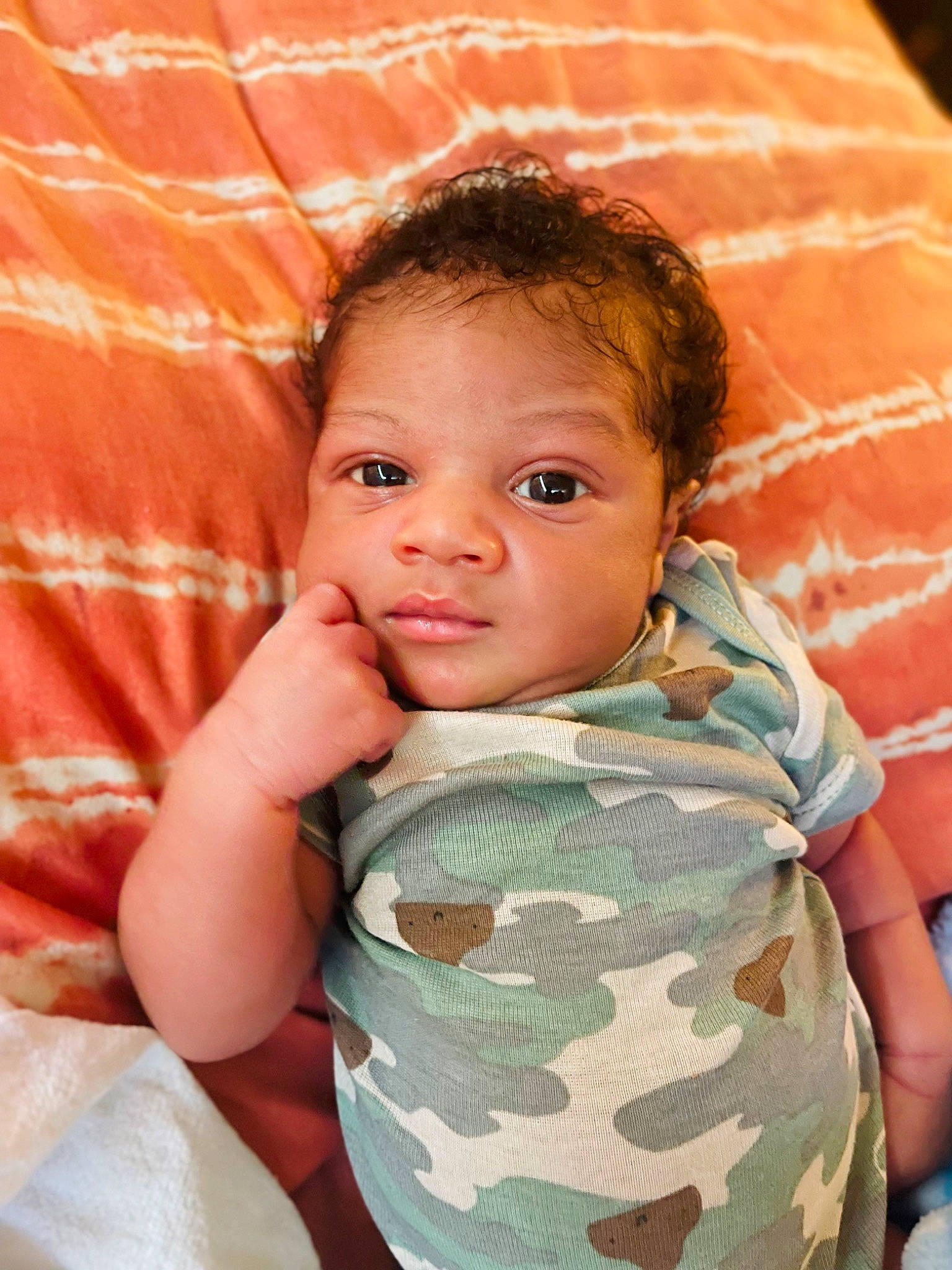 Maijor is registered to the contest to win money with this photo: baby, cheek, chin, comfort, eye, eyebrow, fun, gesture, happy, head, iris, lip, military_camouflage, mouth, nose, person, skin, sleeve, smile, textile