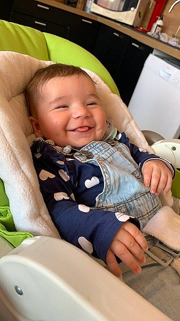 Lou participe au concours pour gagner de l'argent avec cette photo : arm, baby, baby_toddler_clothing, chair, cheek, child, comfort, face, facial_expression, finger, fun, hand, happy, iris, joy, peripheral, person, skin, sleeve, smile