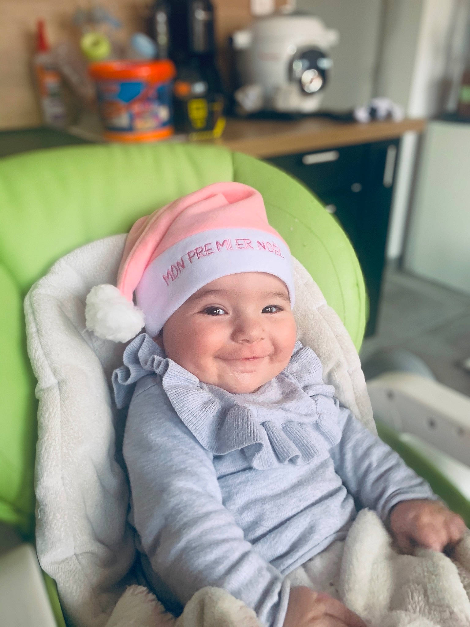 Lou participe au concours pour gagner de l'argent avec cette photo : baby, baby_products, baby_toddler_clothing, beanie, cap, cheek, child, comfort, face, facial_expression, fashion_accessory, fun, happy, headwear, joy, knit_cap, person, room, sitting, skin