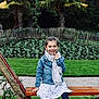 Lou a rejoint le concours — aidez-le/la à gagner de superbes lots ! bench, casual_clothing, child, daytime, denim_jacket, dress, garden, girl, grass, greenery, happy, nature, outdoor, palm_trees, park, plants, portrait, scarf, sitting, smiling
