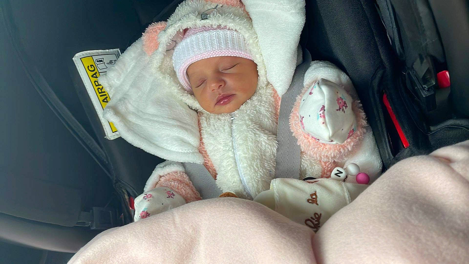 Naomie a rejoint le concours — aidez-le/la à gagner de superbes lots ! auto_part, baby, baby_carriage, baby_in_car_seat, baby_products, baby_safety, baby_sleeping, baby_toddler_clothing, car_seat, carmine, child, comfort, headwear, human_body, linens, nail, person, seat_belt, sitting, thumb