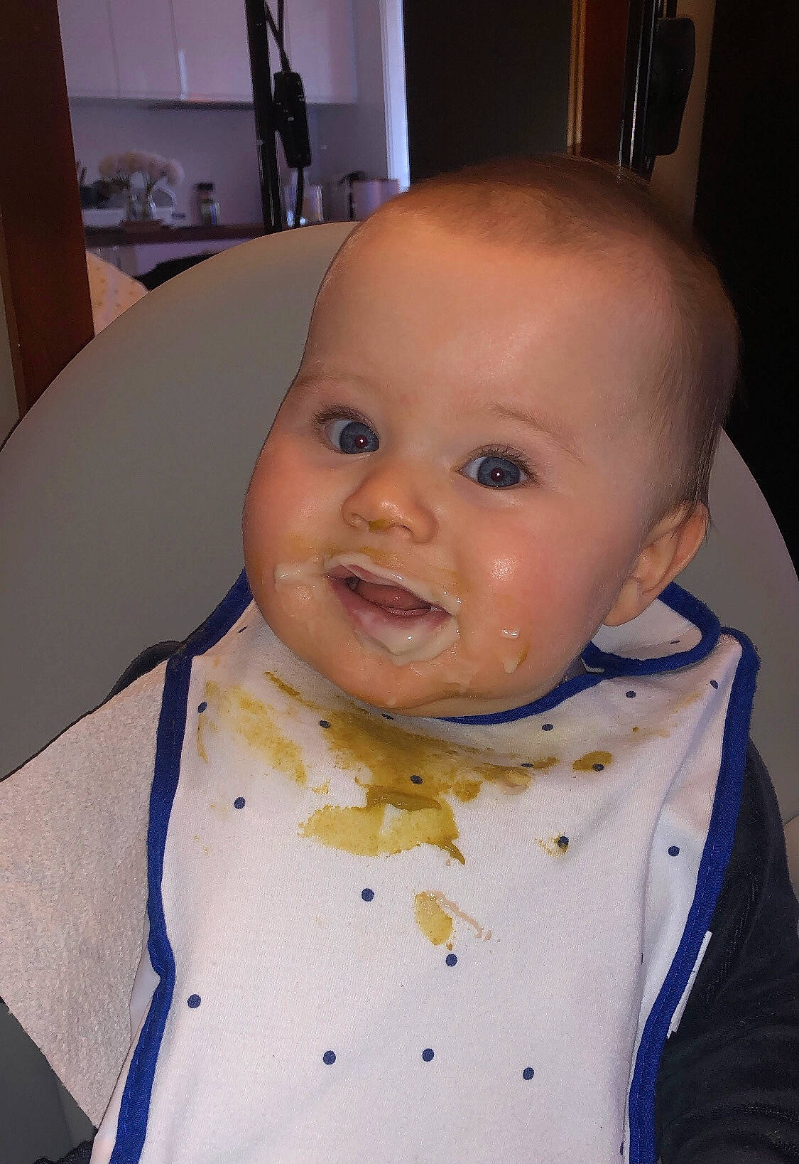 Mia participe au concours pour gagner de l'argent avec cette photo : baby, baby_toddler_clothing, chair, cheek, chin, drinkware, eye, eyebrow, face, happy, head, iris, joy, lip, mouth, nose, person, skin, sleeve, smile