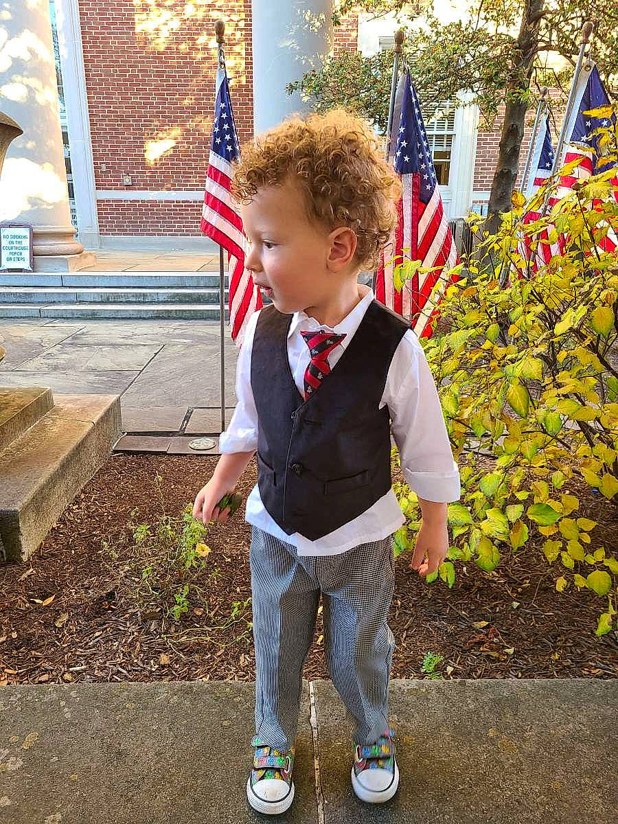 Zain is registered to the contest to win money with this photo: child, denim, electric_blue, event, flag, flag_day_usa, flag_of_the_united_states, fun, grass, holiday, leisure, official, person, plant, sneakers, sunglasses, toddler, tree, uniform, walking