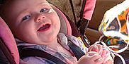Elia is registered to the contest to win money with this photo: baby, bodypart, clothing, coat, cushion, face, finger, hand, happy, hat, head, homedecor, jacket, person, photography, portrait, purple, smile, stroller, transportation