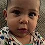 Kaine is registered to the contest to win money with this photo: baby, child, face, eyes, hair, onesie, sports_theme, baseball, basketball, football, couch, texture, hand, brush, teal, closeup, indoor, curious, cute, infant