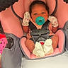 baby, infant, car_seat, pacifier, mittens, pink, gray, clothing, person, child, seatbelt, footwear, socks, indoor, cute, young, newborn, face, head, sitting