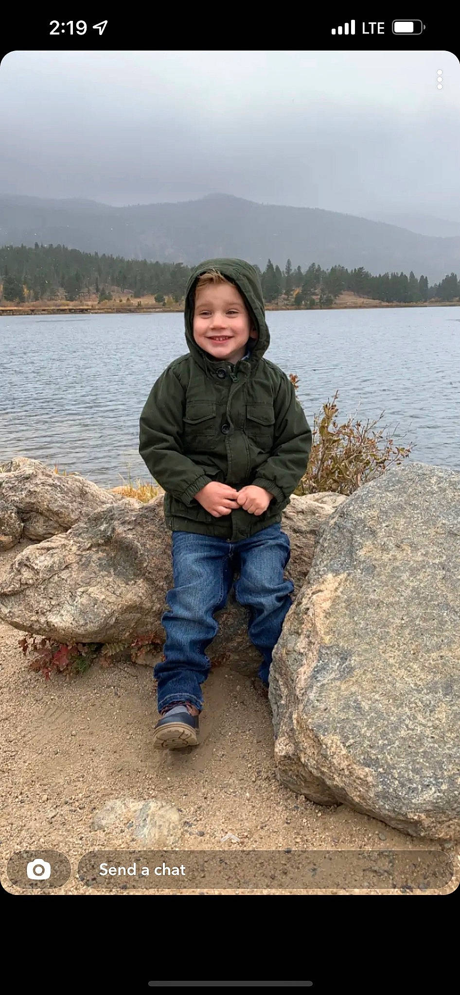 Blayne is registered to the contest to win money with this photo: bedrock, coast, denim, face, fun, happy, headwear, jacket, jeans, joy, lake, landscape, mountain, person, shore, sky, sleeve, smile, travel, tree