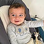 baby, baby_seat, child, clothing, comfort, cushion, cute, elephants, face, giraffe_toy, grey_shirt, happy, indoor, infant, playful, portrait, seatbelt, smiling, toy, young_child